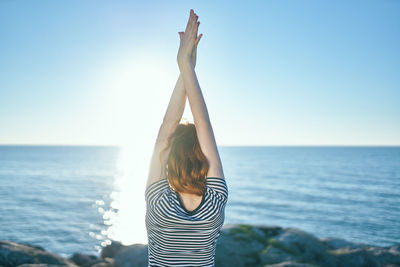 Rear view of young woman looking at sea