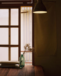 Flower vase on table by window at home