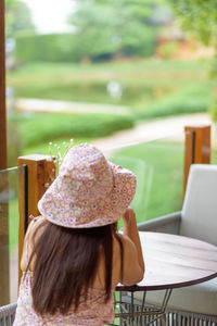 Rear view of woman sitting on table