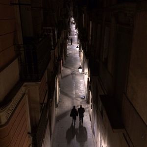 Full length of woman walking on illuminated walkway