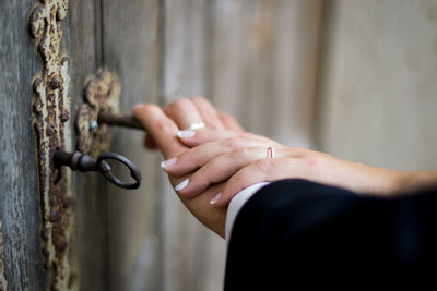 Cropped hands of couple holding key in door