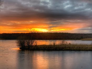 Scenic view of lake against orange sky