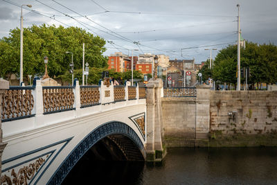 Arch bridge over river against sky