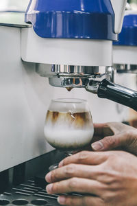 Close-up of person preparing coffee in cafe