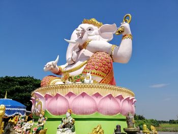 Low angle view of statue against temple against clear sky