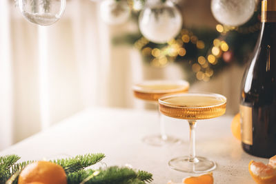 Champagne and tangerines in glasses on table