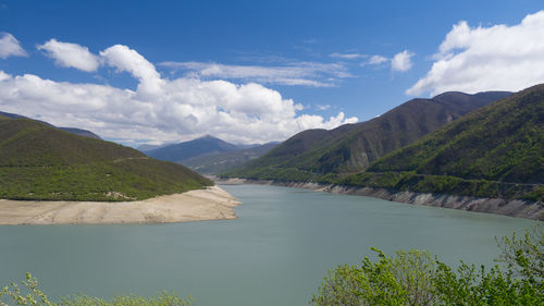 Scenic view of river and mountains against sky