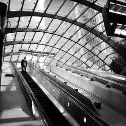 Rear view of man standing on escalator at railroad station