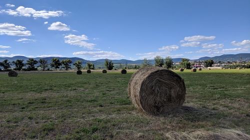 Hay bales on field against sky