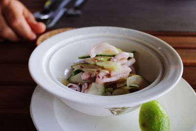 Close-up of hand holding soup in bowl