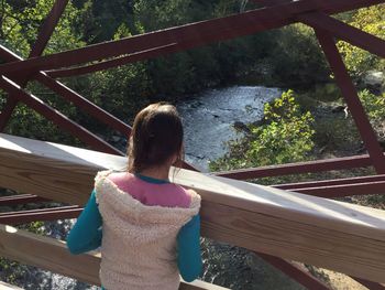 Rear view of woman standing on footbridge