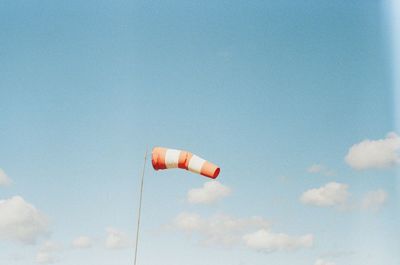 Low angle view of person paragliding against blue sky