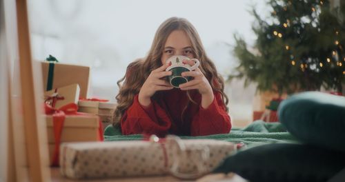 Portrait of young woman sitting on sofa at home