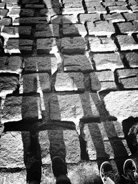 Low section of people standing on tiled floor