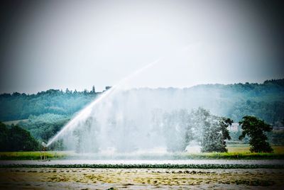 Scenic view of waterfall against sky