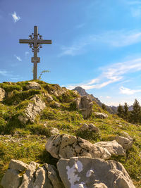 Cross on rock against sky