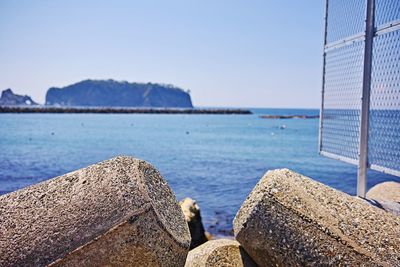 Close-up of rocks on beach against sky