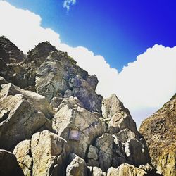 Low angle view of rocks against blue sky