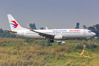 Side view of airplane on runway against sky