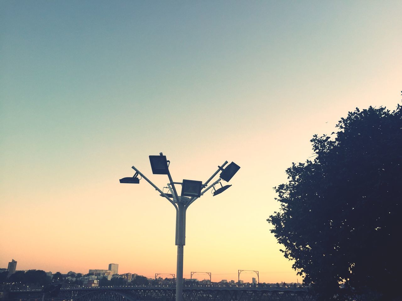 clear sky, sunset, copy space, silhouette, street light, building exterior, lighting equipment, orange color, built structure, low angle view, architecture, city, illuminated, dusk, outdoors, sky, no people, nature, tree, communications tower