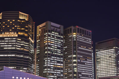 Low angle view of illuminated buildings in city at night
