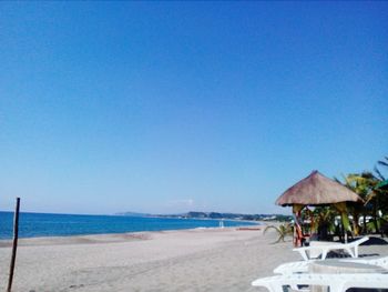 Scenic view of beach against clear blue sky