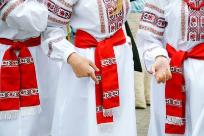 Midsection of women in traditional clothing performing on street