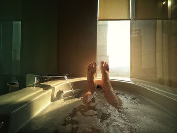 Low section of woman relaxing in bathroom