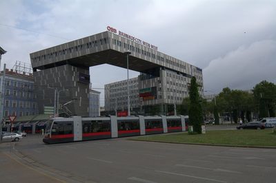 Tram on track against railroad station in city