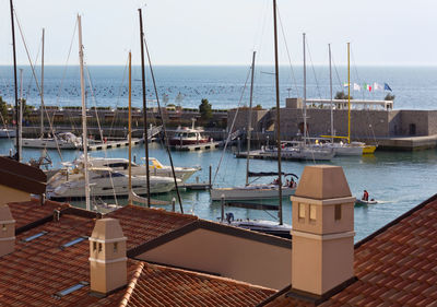 Sailboats moored in harbor