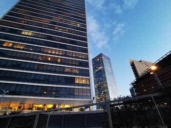 Low angle view of illuminated buildings against sky in city