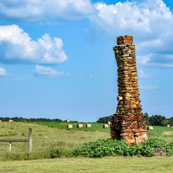 Hay bales on field against sky