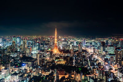 Illuminated cityscape against sky at night