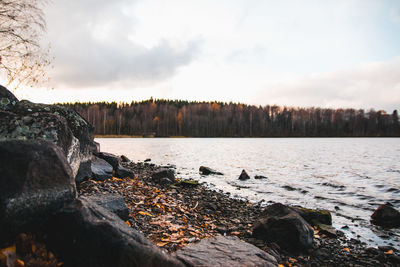 Scenic view of rocks by river against sky