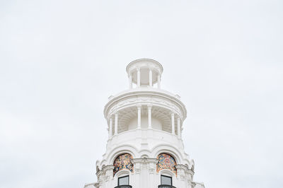 Low angle view of bell tower against building against clear sky