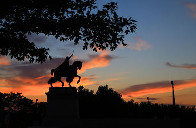 Silhouette statue against sky during sunset