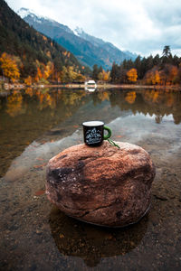Travel mug on the background of the lake and mountains