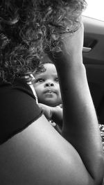 Cute baby boy looking at mother in car