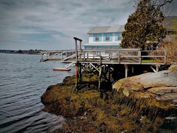 Built structure by sea against sky