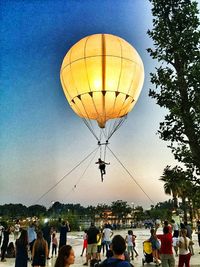 People in hot air balloon against clear sky