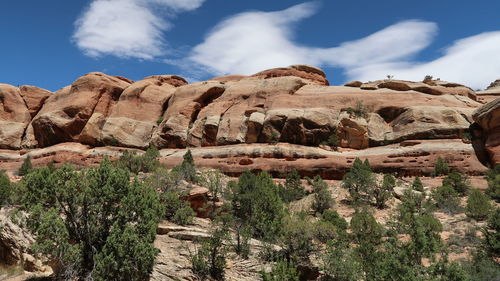 Rocks on mountain against cloudy sky