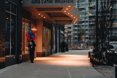 Rear view of man walking on street in city