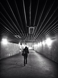 Full length of woman walking in illuminated tunnel