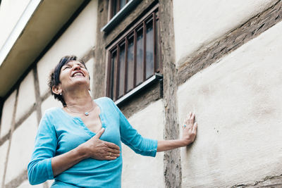 Full length of woman standing against wall