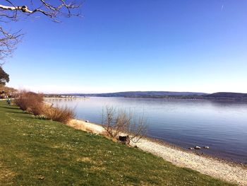 Scenic view of lake against clear blue sky