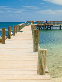 Wooden pier on sea against sky