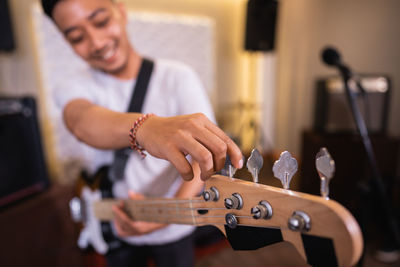 Midsection of man playing guitar