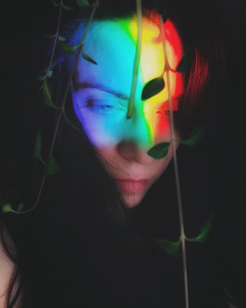 CLOSE-UP OF YOUNG WOMAN WITH MULTI COLORED LIGHT