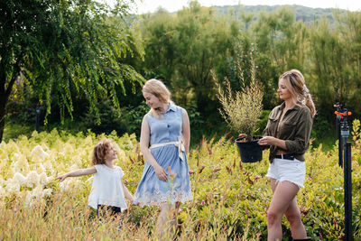 Smiling women with girl standing on field