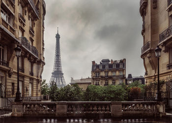 Buildings in city against cloudy sky